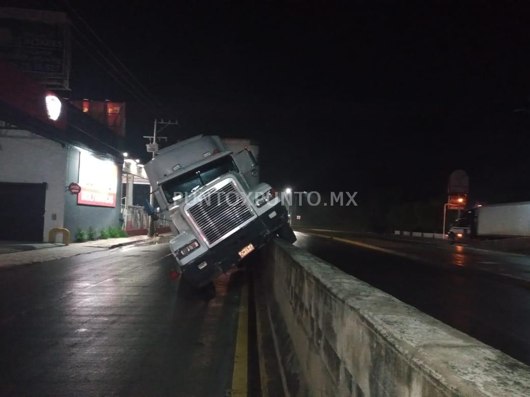 CONDUCTOR DE TRAILER SE SUBE A MURO DE CONCRETO Y QUEDA EMBANCADO EN ALLENDE.